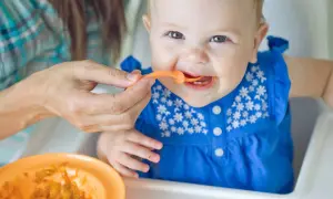 Ein Baby isst Brei. Die Frage, warum Beikost erst ab 6 Monaten empfohlen wird, wird hier bildlich beantwortet: Geduld ist wichtig für die Entwicklung.