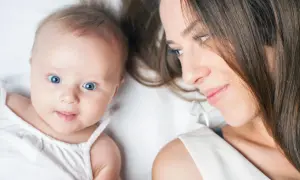 Ein Baby von 23 Wochen mit strahlend blauen Augen blickt neugierig in die Kamera, während seine Mutter es liebevoll ansieht.