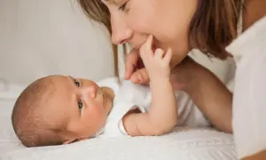 Mutter streichelt ihr Baby, das gerade einen **baby 3 wochen wachstumsschub** durchmacht. Liebevoller Moment zwischen Mutter und Kind.