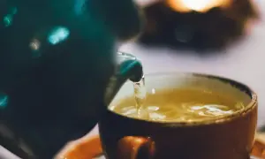 Ein warmer Tee wird in eine Tasse gegossen. Perfekt für die Tee Stillzeit.