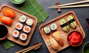 Sushi-Stillzeit: Frischer Lachs, Avocado und Garnelen auf Holzbrettern, bereit zum Genießen. Ein Fest für die Sinne.