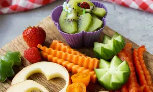 Buntes Obst und Gemüse für ein Baby von 1 Jahr: Erdbeeren, Kiwi, Karotten, Gurken, Paprika, Apfelherzen.