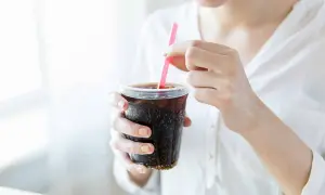 Frau stillt ihren Durst mit einem eiskalten Cola Zero.