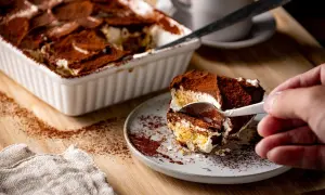 Ein Stück Tiramisu wird mit einer Gabel aus einer Auflaufform genommen. Perfekt für die Stillzeit!