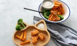 Fischstäbchen mit Brokkoli und Süßkartoffel-Pommes auf einem Katzen-Teller. Ab wann Fisch Baby essen darf, ist eine Frage für Eltern.