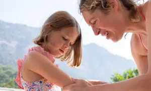Mutter untersucht den Arm ihres Kindes nach einem Wespenstich.