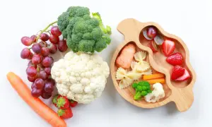 Baby led weaning rezepte: Lachs, Nudeln, Gemüse und Obst auf einem Holztablett.