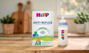 Hipp Anti-Reflux Spezialnahrung für Babys mit Aufstoßen und Spucken. Eine Flasche mit der Nahrung steht neben der Packung.