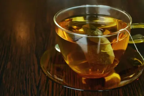 Eine Tasse dampfender schwarztee stillen den Durst.