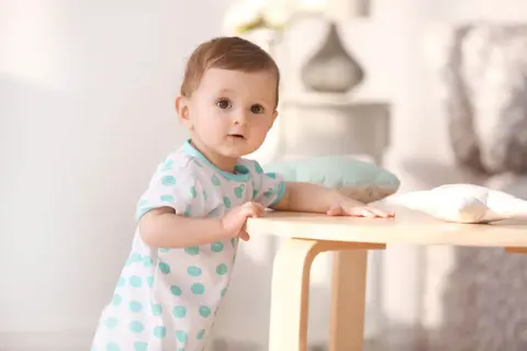 Ein süßes Baby mit großen Augen, das neugierig in die Kamera schaut. So sehen Babys aus, wenn sie die Welt entdecken.