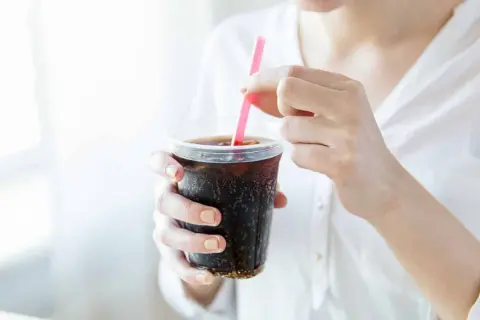 Frau stillt ihren Durst mit einem eiskalten Cola Zero.