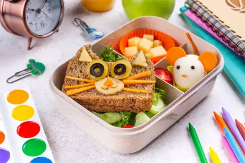 Kreative Vesper Ideen: Ein Brot als Katze mit Olivenaugen und Karotten-Schnurrhaaren, daneben ein Ei als Maus. Perfekt für die Brotdose!