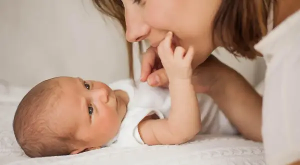 Mutter streichelt ihr Baby, das gerade einen **baby 3 wochen wachstumsschub** durchmacht. Liebevoller Moment zwischen Mutter und Kind.