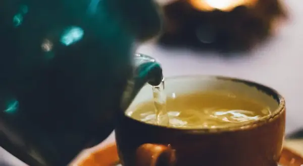 Ein warmer Tee wird in eine Tasse gegossen. Perfekt für die Tee Stillzeit.