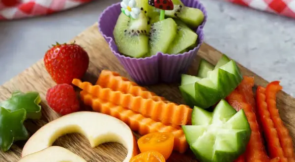 Buntes Obst und Gemüse für ein Baby von 1 Jahr: Erdbeeren, Kiwi, Karotten, Gurken, Paprika, Apfelherzen.