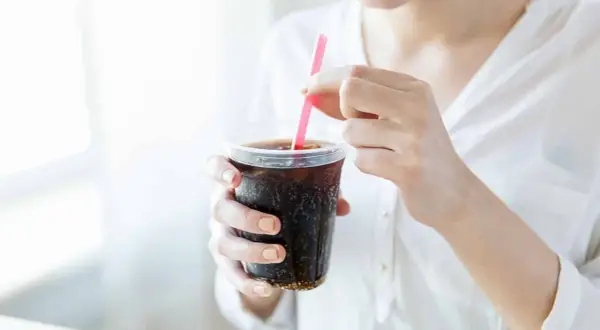 Frau stillt ihren Durst mit einem eiskalten Cola Zero.
