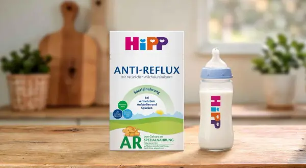 Hipp Anti-Reflux Spezialnahrung für Babys mit Aufstoßen und Spucken. Eine Flasche mit der Nahrung steht neben der Packung.