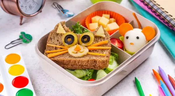 Kreative Vesper Ideen: Ein Brot als Katze mit Olivenaugen und Karotten-Schnurrhaaren, daneben ein Ei als Maus. Perfekt für die Brotdose!