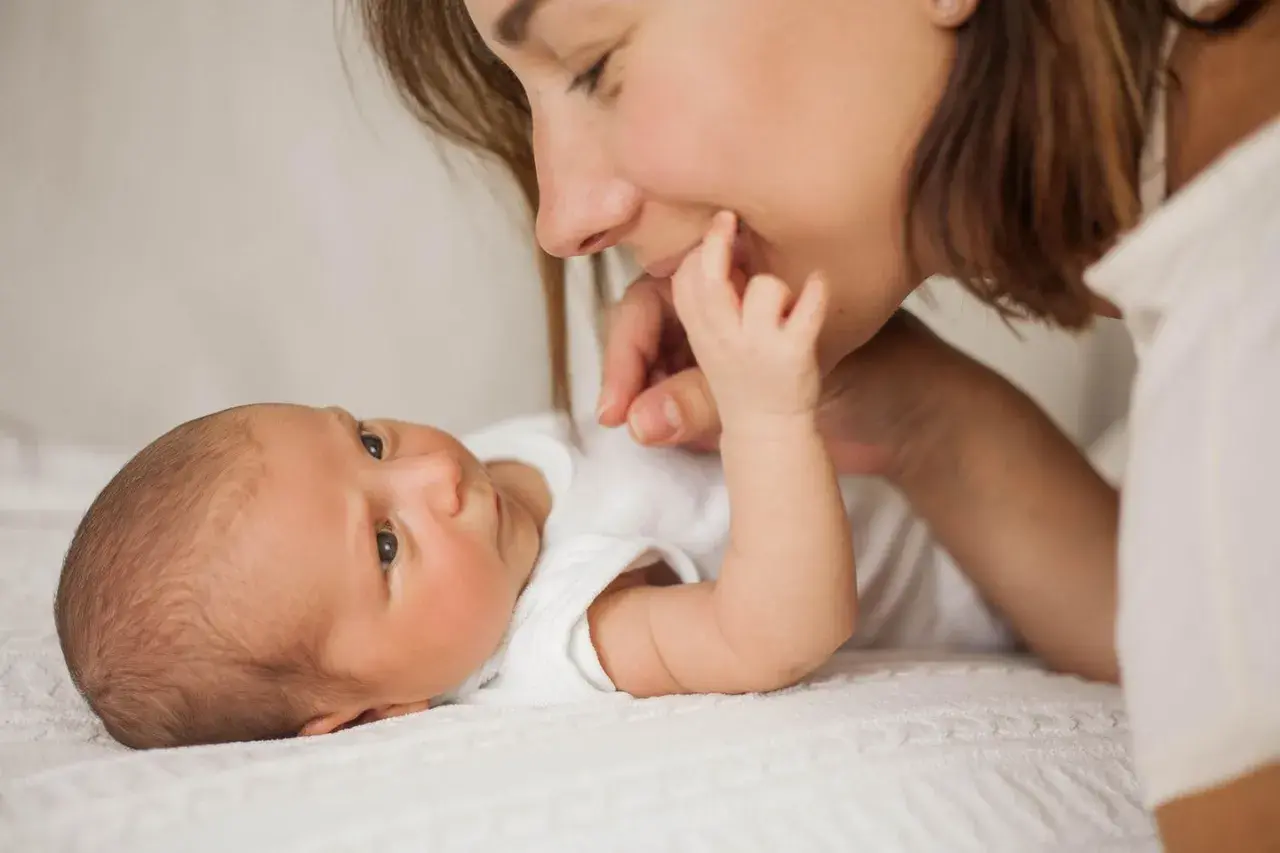 Mutter streichelt ihr Baby, das gerade einen **baby 3 wochen wachstumsschub** durchmacht. Liebevoller Moment zwischen Mutter und Kind.