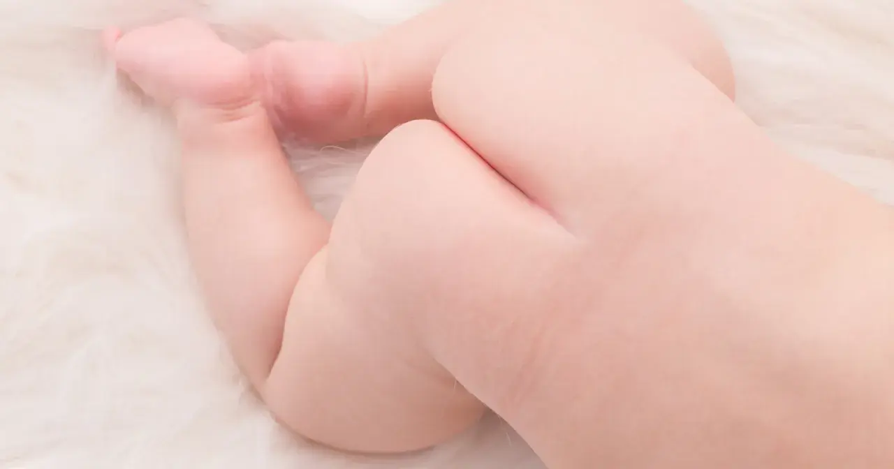 Baby po mit leichten Rötungen, vielleicht durch das Zahnen. Zarte Haut auf weichem Untergrund.