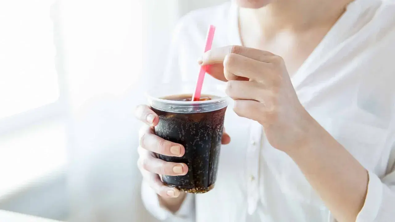 Frau stillt ihren Durst mit einem eiskalten Cola Zero.