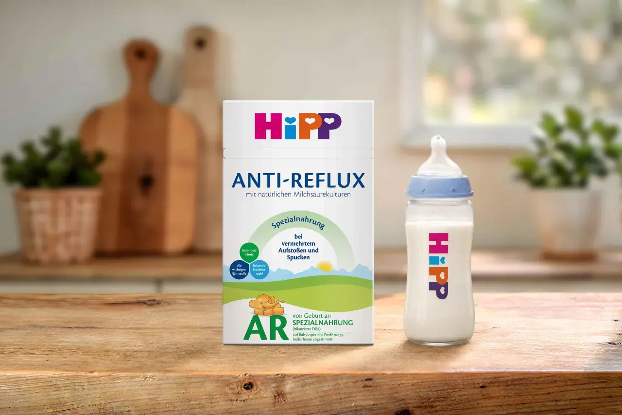 Hipp Anti-Reflux Spezialnahrung für Babys mit Aufstoßen und Spucken. Eine Flasche mit der Nahrung steht neben der Packung.