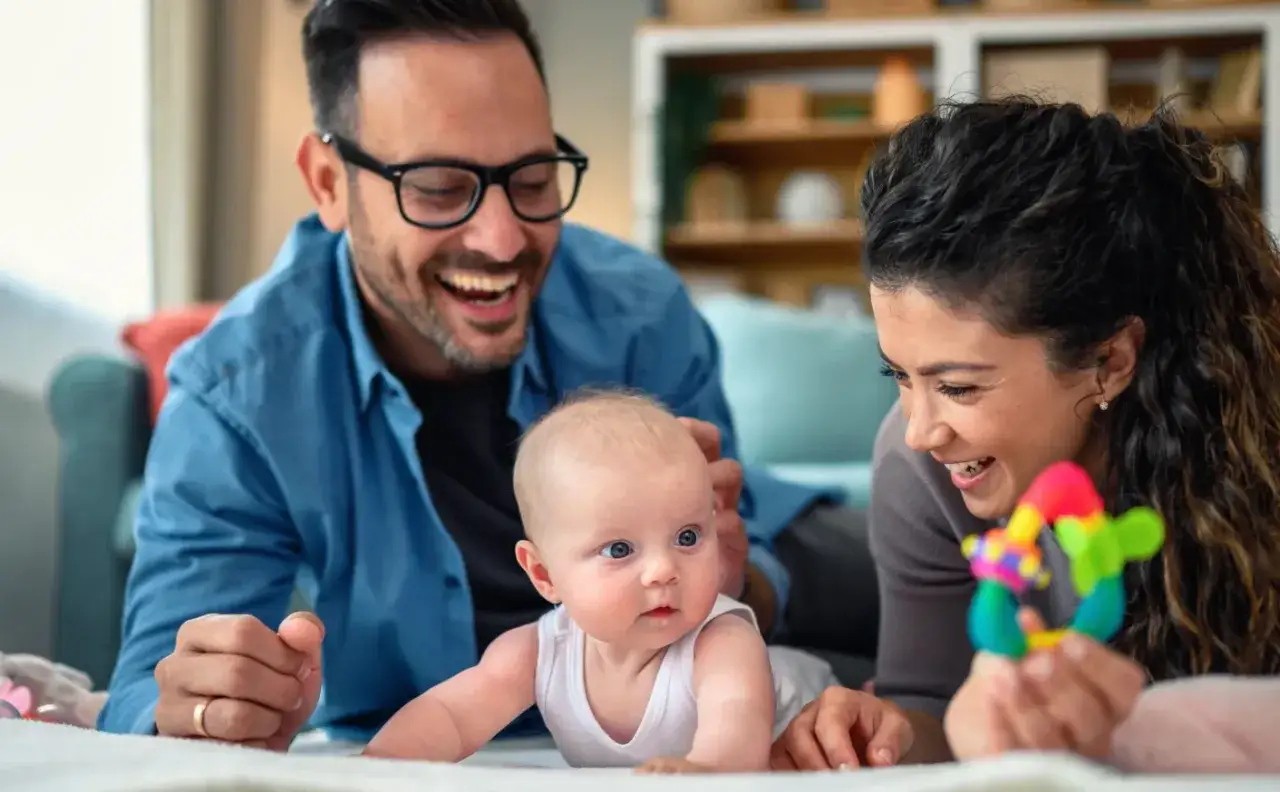 Gl&uuml;ckliche Eltern mit ihrem Baby. Die 4. sprung baby erfahrungen sind voller Lachen und Freude, w&auml;hrend sie mit ihrem Kleinen spielen.
