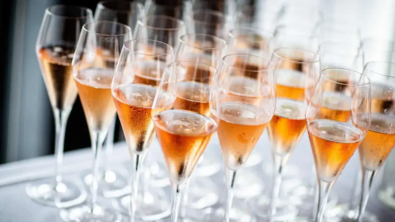 Reihe von Gl&auml;sern mit Ros&eacute;-Sekt, bereit f&uuml;r ein stilles Fest.