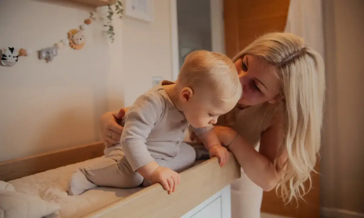 Mutter h&auml;lt ihr Baby fest, das fast vom Wickeltisch gefallen w&auml;re. Ein s&uuml;&szlig;er Moment der Erleichterung.