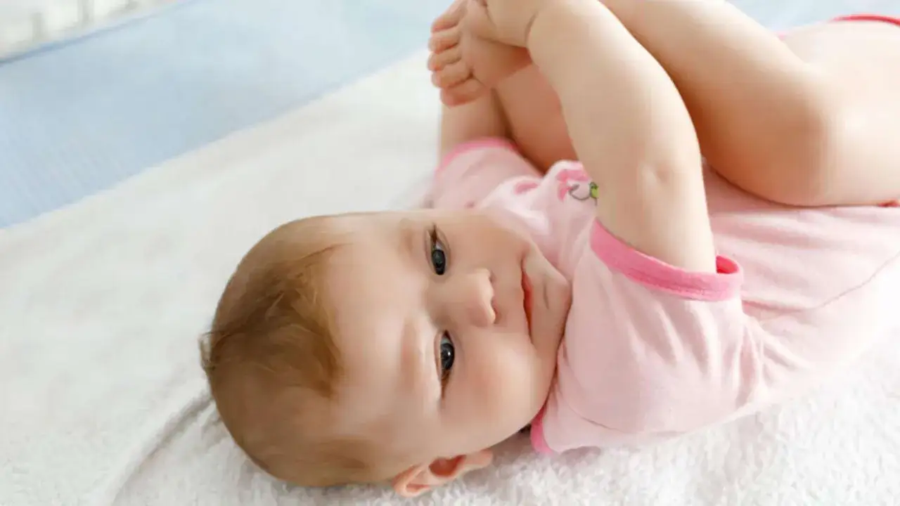 Ein Baby liegt auf dem Rücken und spielt mit seinen Füßen. Es ist etwa 19 Wochen alt und durchläuft gerade einen Wachstumsschub.