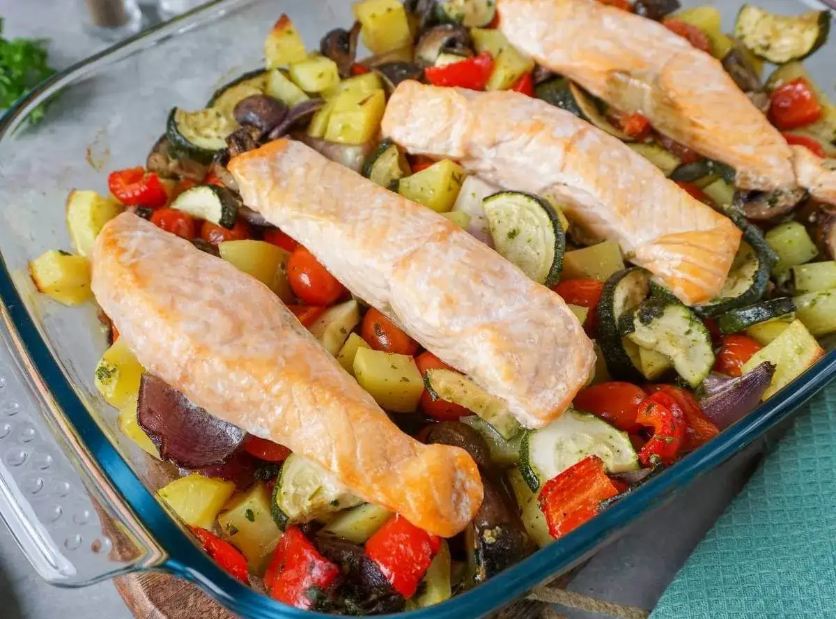 Saftige Lachsfilets auf einem Bett aus Ofengemüse – eine gesunde Mahlzeit, die auch Kindern schmeckt.