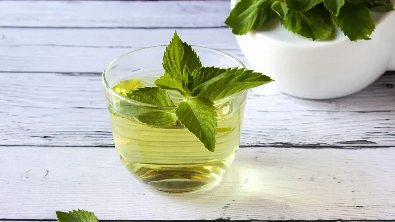 Ein Glas mit erfrischendem Pfefferminztee, garniert mit frischen Minzbl&auml;ttern. Perfekt, um den Durst zu stillen und sich zu erfrischen.
