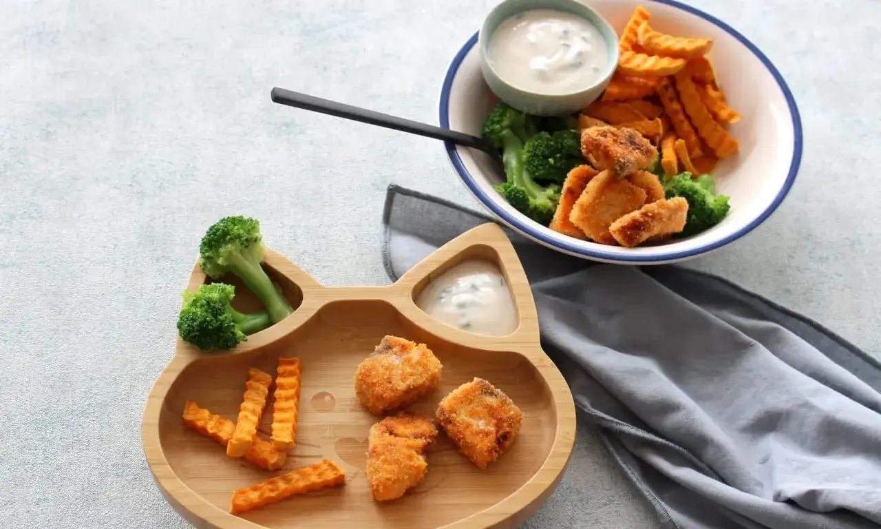 Leckere Fischst&auml;bchen mit S&uuml;&szlig;kartoffel-Pommes und Brokkoli auf einem Katzen-Teller. Ein gesunder Fisch-Babybrei f&uuml;r kleine Entdecker.