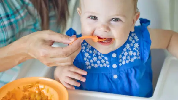 Ein Baby isst Brei. Die Frage, warum Beikost erst ab 6 Monaten empfohlen wird, wird hier bildlich beantwortet: Geduld ist wichtig für die Entwicklung.