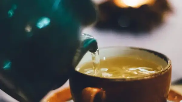 Ein warmer Tee wird in eine Tasse gegossen. Perfekt für die Tee Stillzeit.
