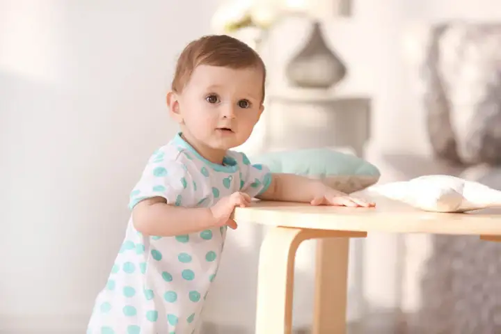 Ein süßes Baby mit großen Augen, das neugierig in die Kamera schaut. So sehen Babys aus, wenn sie die Welt entdecken.